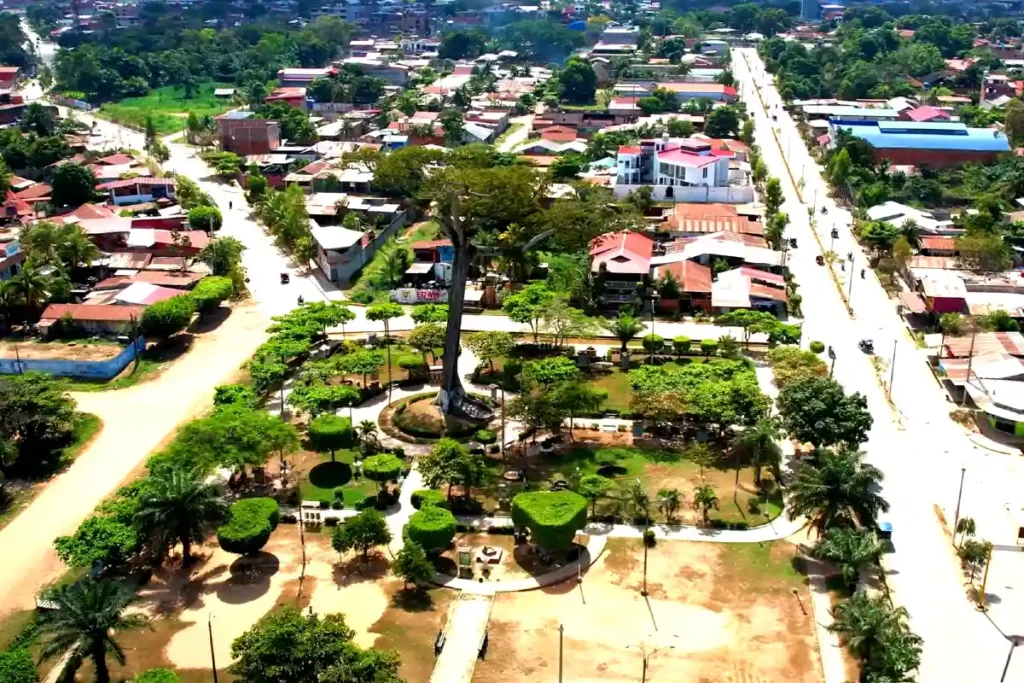 Vista aérea de Pucallpa con su parque central, grandes árboles, calles amplias y viviendas típicas de la Amazonía peruana.