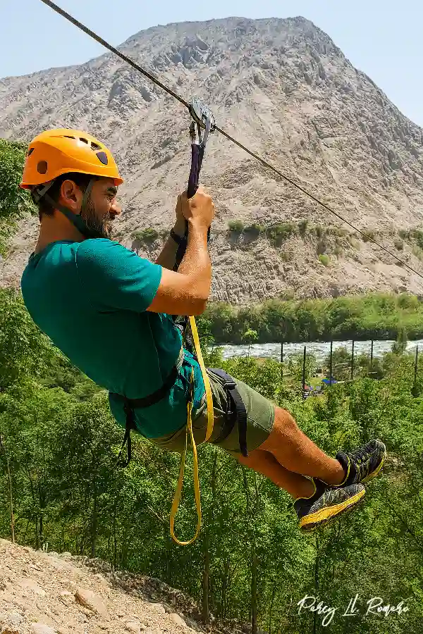 Turista brasileño deslizándose en tirolesa sobre el valle de Lunahuaná, una actividad imperdible dentro del turismo en Cañete.
